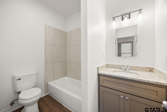 bathroom with shower / washtub combination, toilet, vanity, wood finished floors, and baseboards