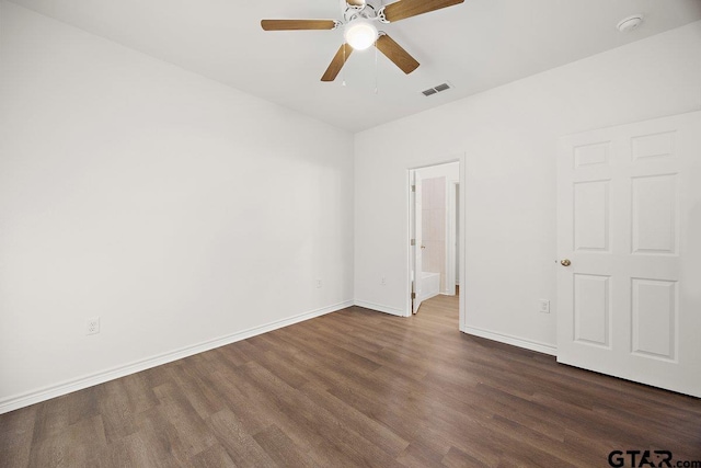 empty room with a ceiling fan, wood finished floors, visible vents, and baseboards