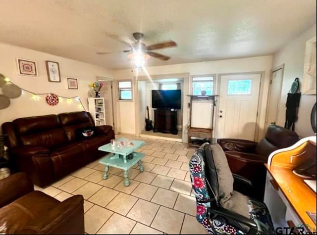 living room featuring light tile patterned flooring, ceiling fan, and plenty of natural light