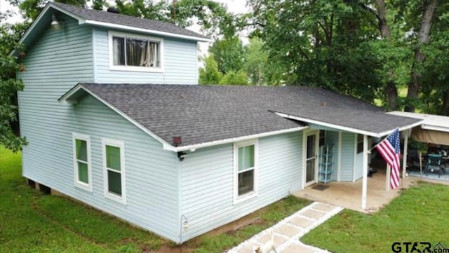 rear view of house featuring a yard and a patio area