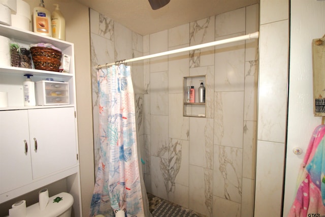 full bathroom with toilet, a stall shower, and a ceiling fan