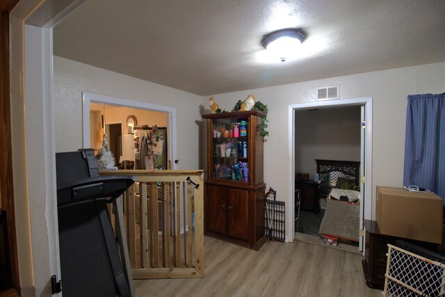 interior space featuring visible vents, wood finished floors, and a textured ceiling