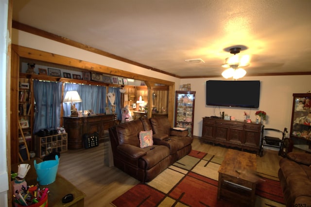 living room featuring wood finished floors and crown molding