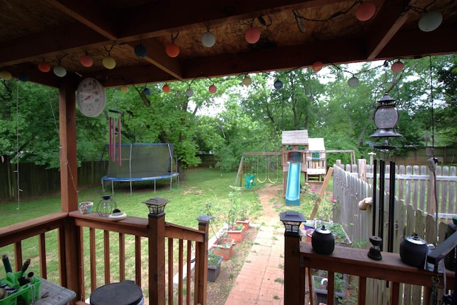 view of yard featuring a fenced backyard, a playground, and a trampoline