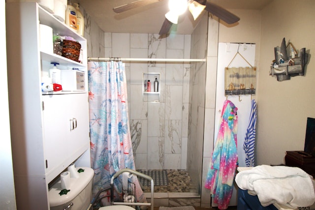 bathroom featuring toilet, a stall shower, and ceiling fan