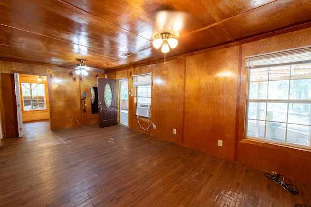 empty room featuring wood walls, hardwood / wood-style floors, wooden ceiling, and ceiling fan