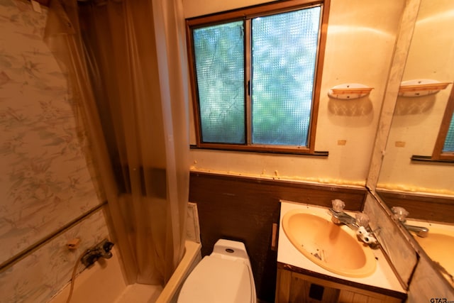 bathroom with curtained shower, vanity, and toilet