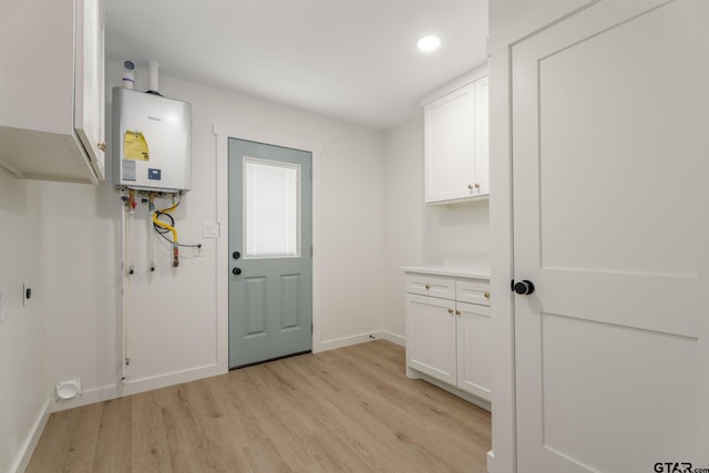 304 Hanks St, Whitehouse, TX 75791 - laundry room featuring tankless water heater, hookup for an electric dryer, light wood-style flooring, and recessed lighting
