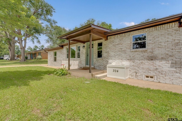 304 Hanks St, Whitehouse, TX 75791 - back of house featuring a yard and brick siding
