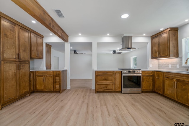 304 Hanks St, Whitehouse, TX 75791 - kitchen with stainless steel gas stove, island exhaust hood, a peninsula, light wood-type flooring, and recessed lighting