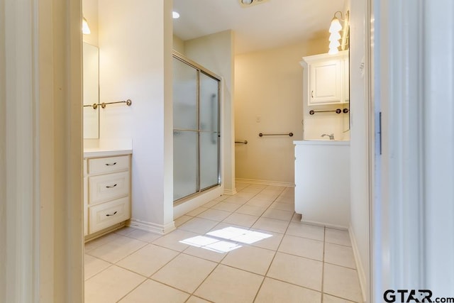 full bathroom with tile patterned flooring, a shower stall, vanity, and baseboards