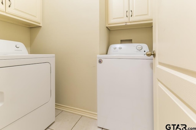 laundry area with cabinet space, independent washer and dryer, baseboards, and light tile patterned flooring