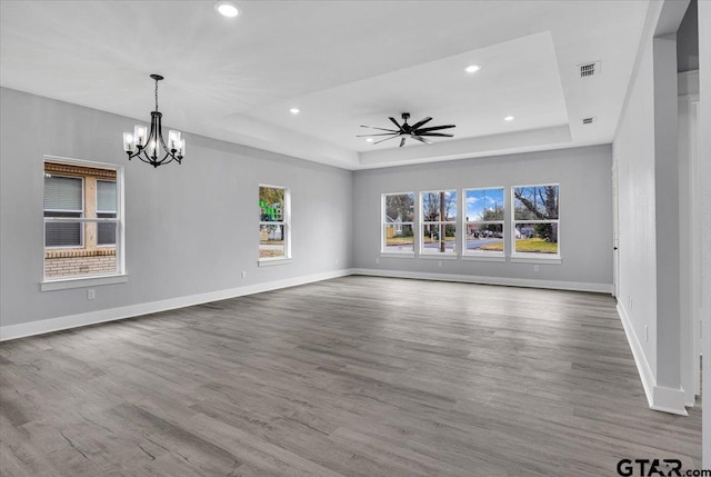 unfurnished living room featuring hardwood / wood-style flooring and a tray ceiling