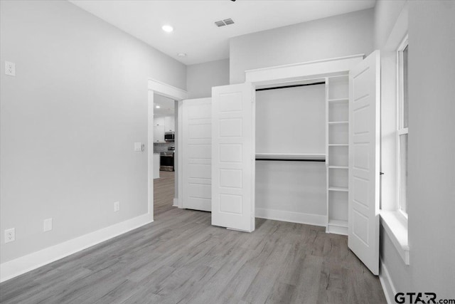 unfurnished bedroom featuring light hardwood / wood-style floors and a closet