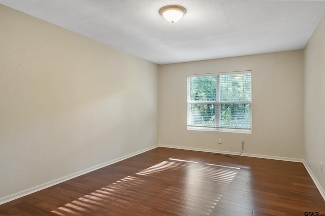 unfurnished room featuring dark wood-type flooring