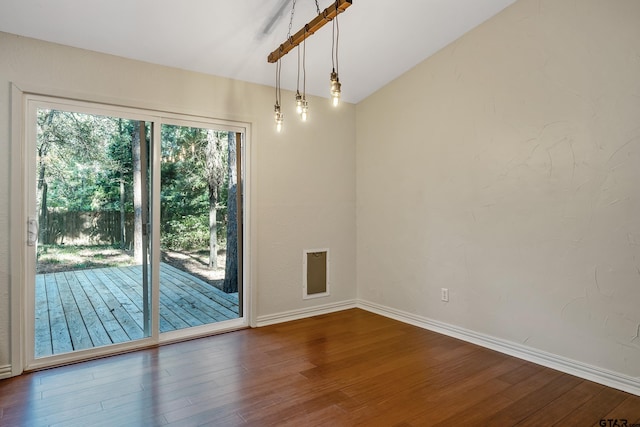 unfurnished dining area featuring hardwood / wood-style floors and vaulted ceiling