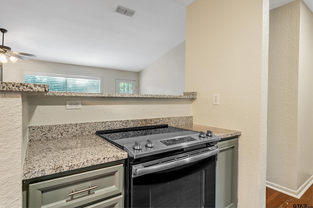 kitchen featuring stainless steel electric range, dark wood-type flooring, ceiling fan, and light stone counters