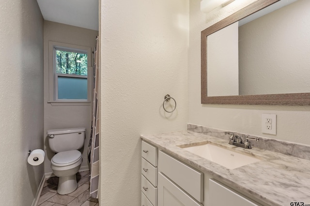 bathroom featuring curtained shower, vanity, tile patterned floors, and toilet