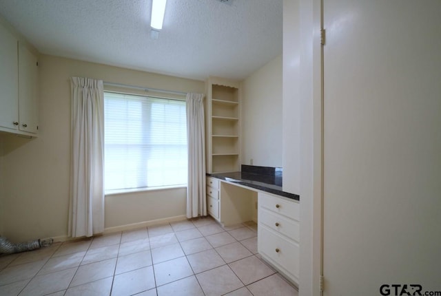 4505 Inverness, Tyler, TX 75703 - unfurnished office featuring built in desk, a textured ceiling, baseboards, and light tile patterned floors