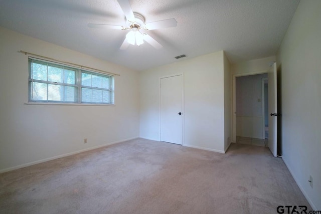 4505 Inverness, Tyler, TX 75703 - unfurnished bedroom featuring light colored carpet, ceiling fan, a textured ceiling, and baseboards