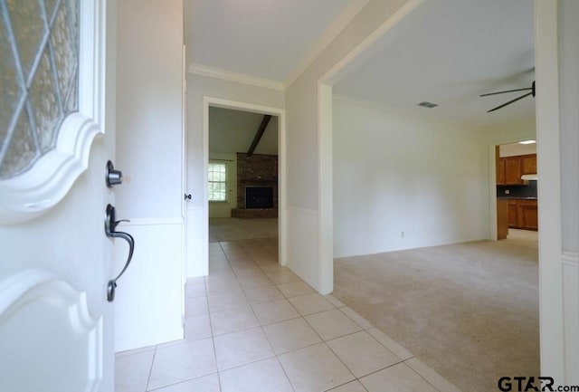 4505 Inverness, Tyler, TX 75703 - foyer featuring light carpet, a fireplace, crown molding, light tile patterned floors, and ceiling fan