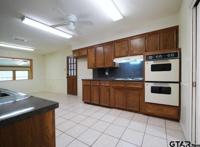 4505 Inverness, Tyler, TX 75703 - kitchen with white appliances, dark countertops, under cabinet range hood, a textured ceiling, and a ceiling fan