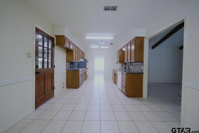 4505 Inverness, Tyler, TX 75703 - kitchen with light tile patterned floors, a sink, and brown cabinets