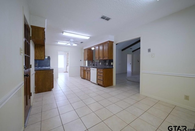 4505 Inverness, Tyler, TX 75703 - kitchen featuring dishwasher, decorative backsplash, dark countertops, light tile patterned flooring, and a textured ceiling