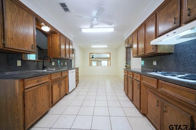 4505 Inverness, Tyler, TX 75703 - kitchen featuring a sink, under cabinet range hood, white appliances, dark countertops, and a textured ceiling
