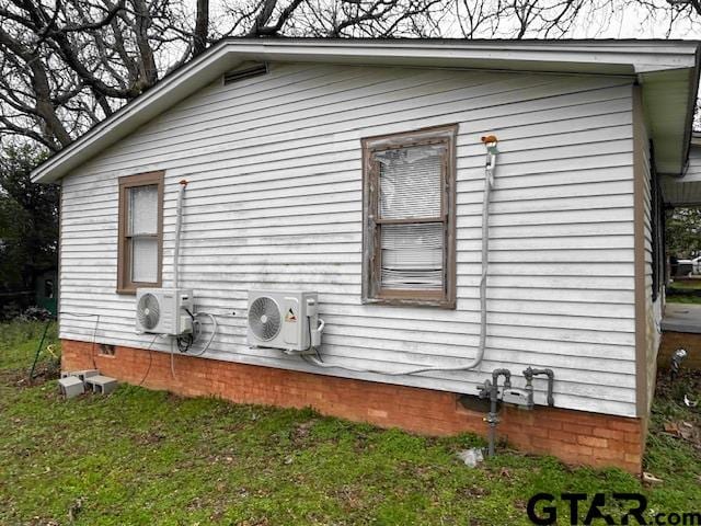 view of property exterior with a yard and ac unit