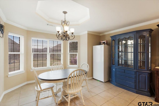 tiled dining room with crown molding, a raised ceiling, and a chandelier