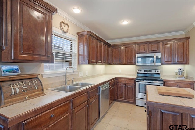 kitchen with sink, tile counters, stainless steel appliances, and light tile patterned flooring