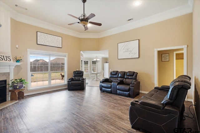 living room with crown molding, hardwood / wood-style flooring, and ceiling fan with notable chandelier