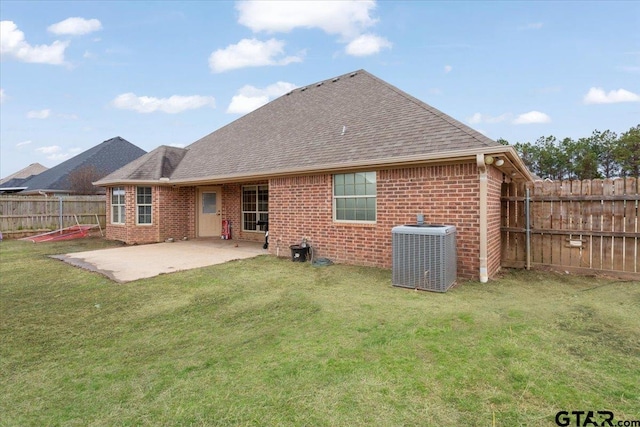 rear view of property featuring cooling unit, a lawn, and a patio