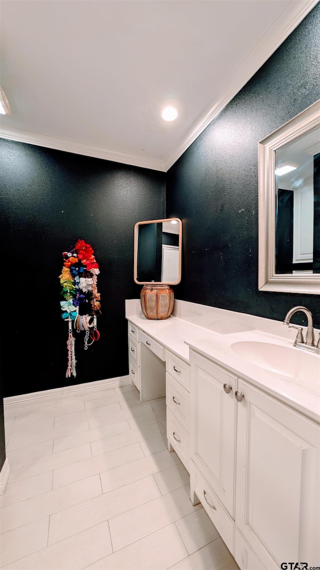 bathroom with crown molding, a textured wall, and vanity