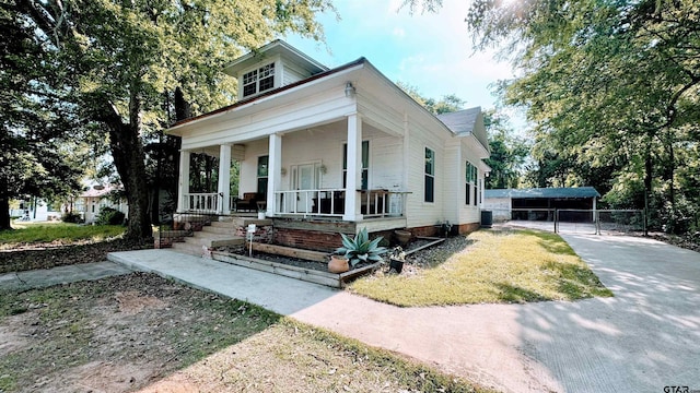 neoclassical / greek revival house featuring fence and covered porch
