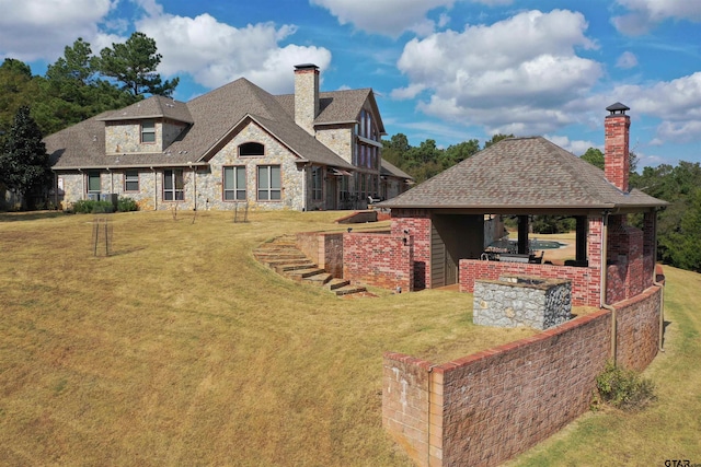 exterior space featuring a gazebo, a yard, and an outdoor kitchen