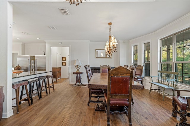 dining room with a wealth of natural light, crown molding, and hardwood / wood-style flooring