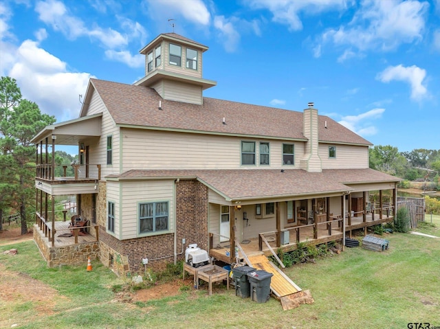 back of house featuring a lawn and a deck