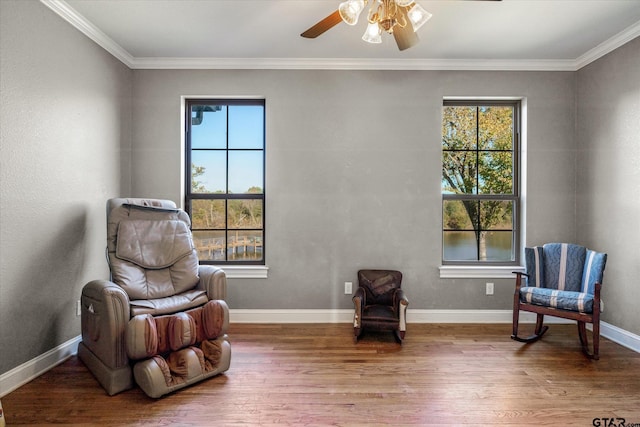 sitting room featuring hardwood / wood-style flooring, ceiling fan, and crown molding