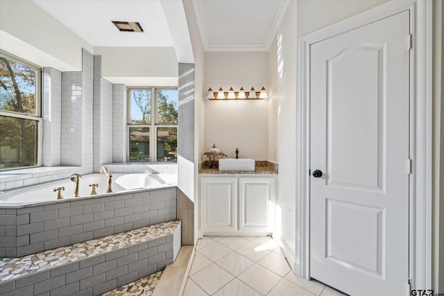 bathroom featuring tile patterned flooring, vanity, a relaxing tiled tub, and a healthy amount of sunlight