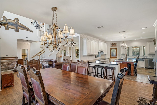 dining space featuring light hardwood / wood-style floors, ornamental molding, and an inviting chandelier