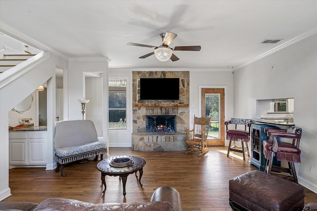 living room with a fireplace, ceiling fan, dark hardwood / wood-style flooring, and crown molding