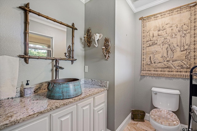 bathroom featuring vanity, toilet, and ornamental molding