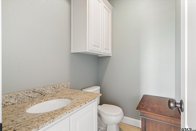 bathroom with tile patterned flooring, vanity, and toilet