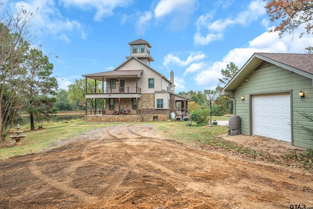 rear view of property with a balcony and a porch