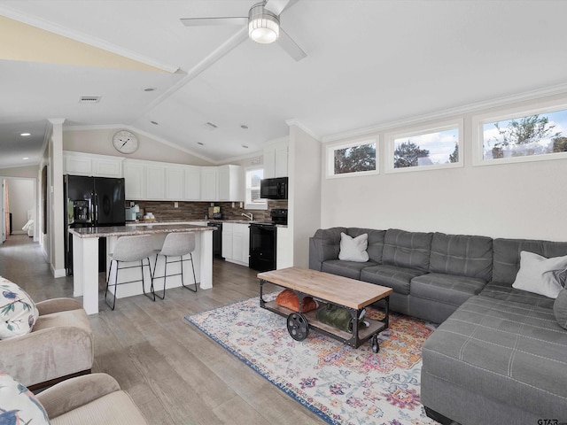 living room featuring lofted ceiling, sink, ceiling fan, crown molding, and light hardwood / wood-style flooring