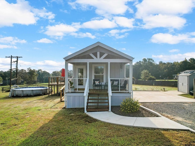 view of outdoor structure with a yard, a fenced in pool, and covered porch