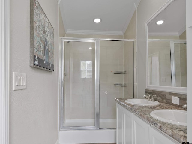 bathroom featuring vanity, crown molding, and a shower with door