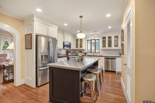kitchen with glass insert cabinets, appliances with stainless steel finishes, tasteful backsplash, and white cabinetry